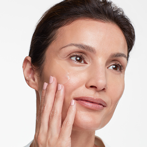 Een model brengt het HydroPeptide Power Serum aan op haar gezicht om de huid te hydrateren en te verjongen.