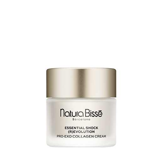 Een vrouw houdt de pot Natura Bissé Essential Shock (R)evolution Pro-Exo Collagen Cream vast, gefotografeerd in een warme, elegante setting.