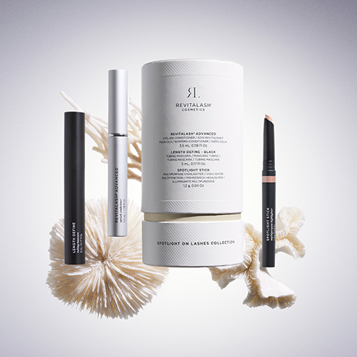 Artistieke compositie van de RevitaLash Spotlight on Lashes collectie geplaatst tussen decoratieve koraalstructuren tegen een zachte achtergrond.