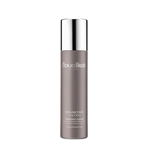 Een slanke, grijze flacon van Natura Bissé Diamond Cocoon Hydrating Essence met een glanzende zilveren dop.