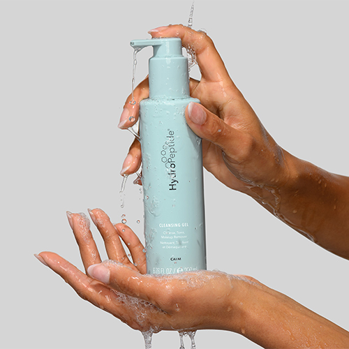 Handen die HydroPeptide Cleansing Gel gebruiken met water en schuim