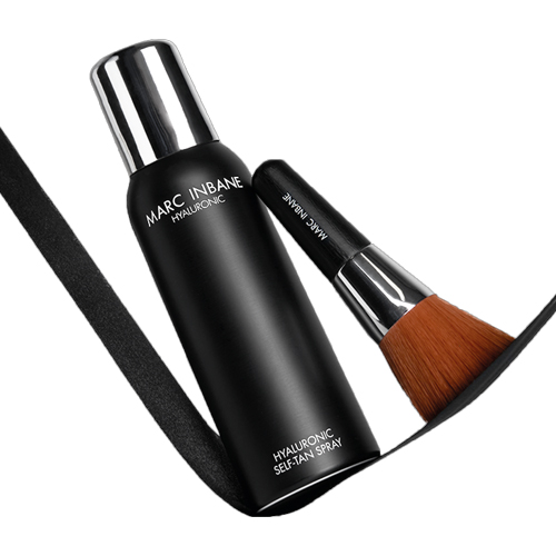 De Marc Inbane hyaluronic self tan spray en de compacte tanning brush liggend op een zwarte achtergrond