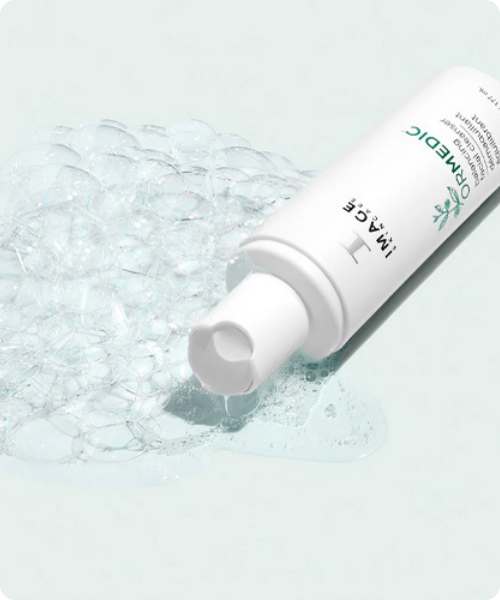 De IMAGE Skincare ORMEDIC Balancing Facial Cleanser liggend afgebeeld naast een milde, schuimende geltextuur met frisse luchtbelletjes.