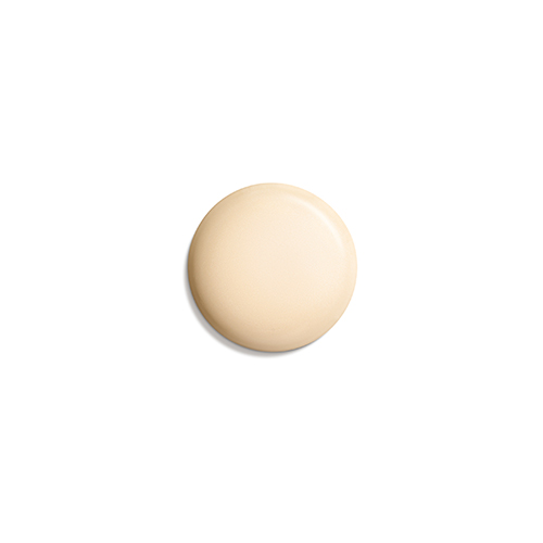 Een perfect ronde, gladde klodder matte beige foundation of make-up primer, gecentreerd tegen een effen witte achtergrond.