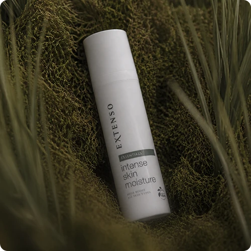 Een witte flacon van Extenso Essentials Intense Skin Moisture rust in groen mos, ideaal voor intense hydratatie en een gezonde summer glow.