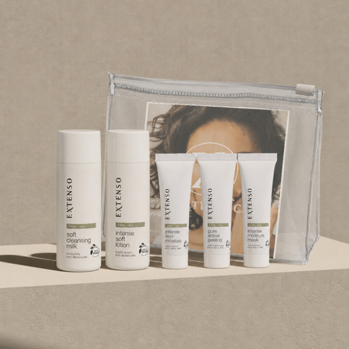Extenso travel set met verzorgingsproducten en een toilettas gepresenteerd op een houten blok in een sfeervolle setting
