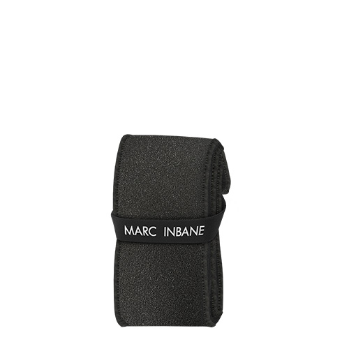 Een productafbeelding van de opgerolde zwarte Marc Inbane exfoliërende rugscrubber met een merkband eromheen
