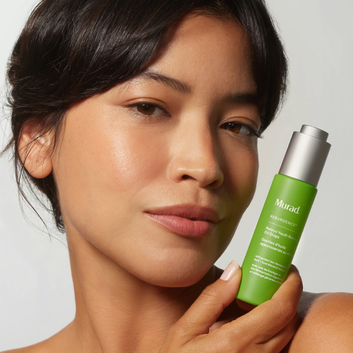 Model houdt Murad Retinol Youth Renewal Oil Drops flacon vast bij haar gezicht