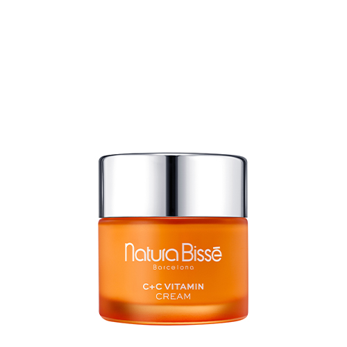 Een luxe oranje glazen pot van Natura Bissé C+C Vitamin Cream met een zilverkleurige deksel op een witte achtergrond.