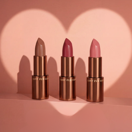 Drie verschillende kleuren Cent Pur Cent lipbalsems gepresenteerd in een hartvormige belichting.