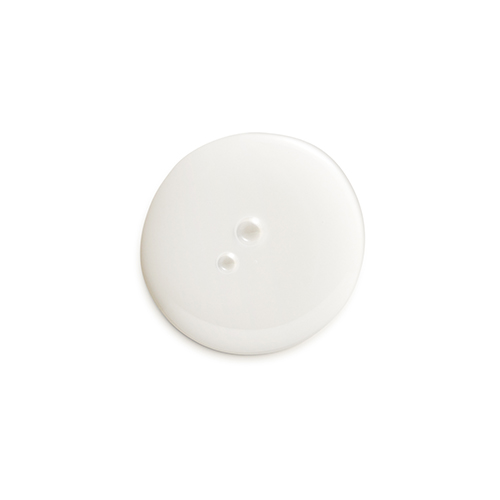 Een klodder witte crème op een witte achtergrond, wat de textuur van het product laat zien.