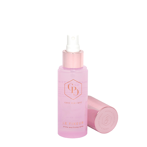 Een geopende roze flacon van Cent Pur Cent Le Fixeur prime and fixing spray waarbij de witte spraykop zichtbaar is en de glanzende roze dop erachter ligt op een witte achtergrond.