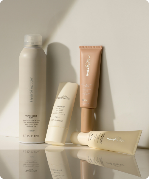 Hydropeptide protect productlijn met beige zonnebrandcrèmes en sprays in een lichte studio opstelling