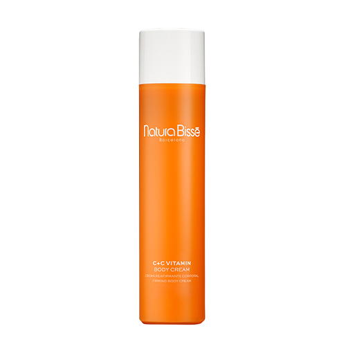 Een grote oranje tube Natura Bissé C+C Vitamin Body Cream met een witte draaidop, staand gefotografeerd tegen een witte achtergrond.