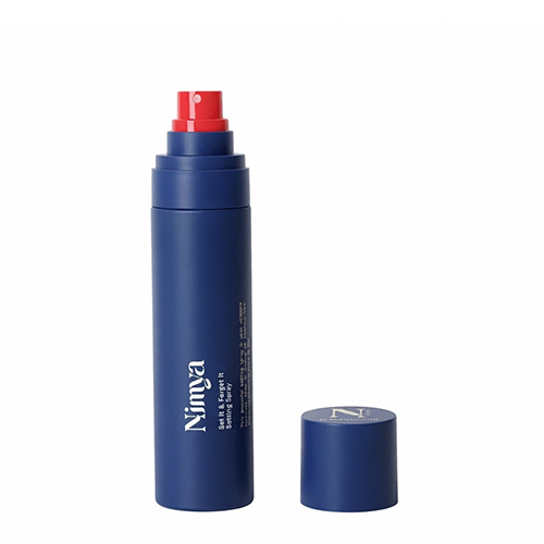 Een open blauwe flacon van de Nimya Set It and Forget It setting spray van 90ml met de dop ernaast, waarbij de rode sproeikop zichtbaar is.