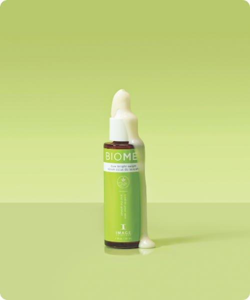 IMAGE-Skincare-BIOME+-Dew-Bright-Serum-30ml-witte-textuur-op-flesje-dat-rechtop-staat-groene-achtergrond