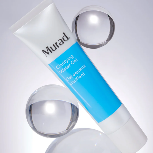 Een blauwe tube Murad Clarifying Water Gel gepositioneerd tussen glazen waterbubbels