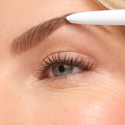 Close-up van het aanbrengen van het Jane Iredale PureBrow Shaping Pencil op een wenkbrauw voor een strakke en natuurlijke vormgeving.