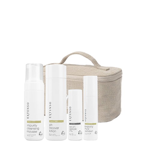 De producten van de Extenso dagelijkse huidverzorgingsroutine voor een heldere huid, inclusief reinigingsmousse en serum, naast een toilettas.