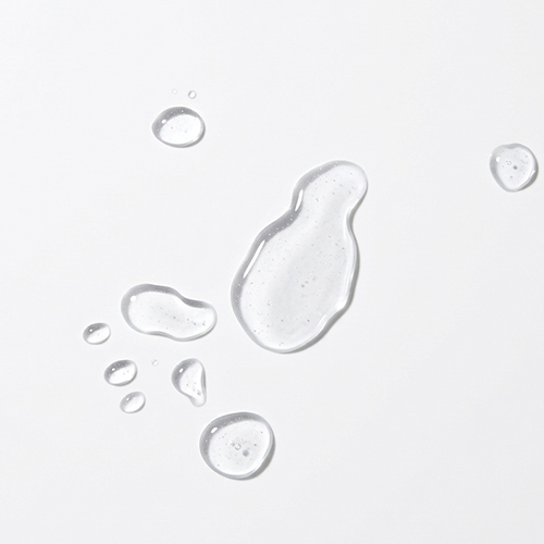 Textuur van de jane iredale BeautyPrep Face Toner, weergegeven als vloeibare, waterige druppels die over een wit oppervlak verspreid liggen.