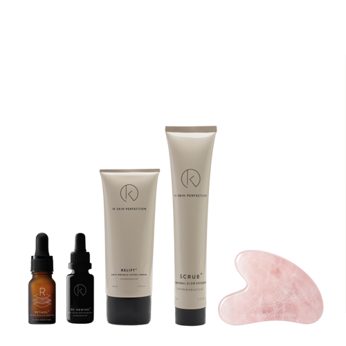 De volledige inhoud van de IK Skin Perfection kerstset bestaande uit twee druppelflesjes, twee tubes crème en een rozenkwarts gua sha steen tegen een witte achtergrond.