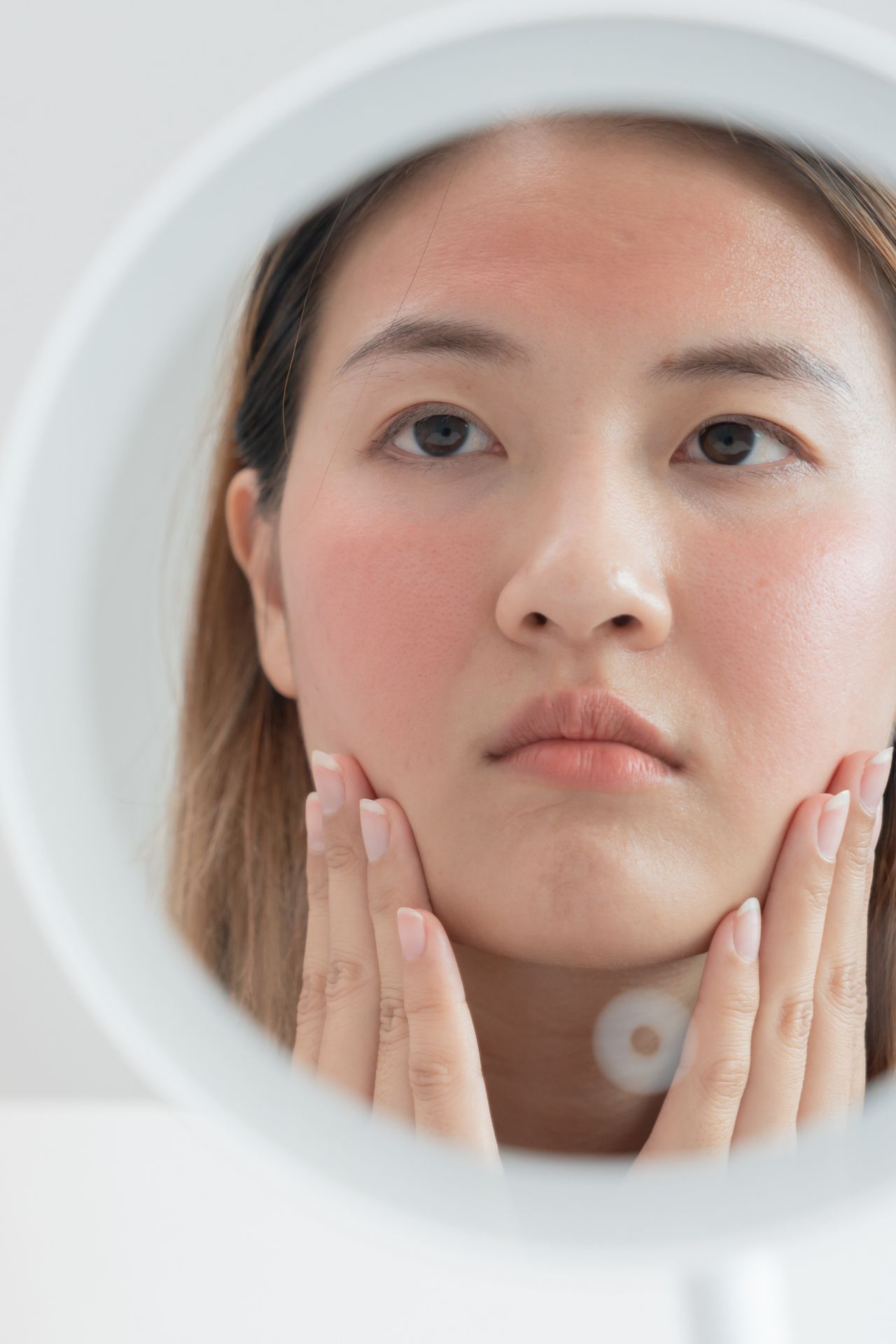 Vrouw kijkt in een spiegel naar haar huidirritatie