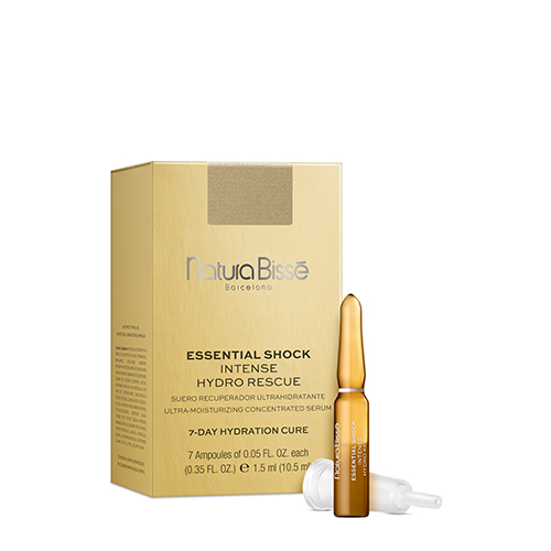 Een goudkleurige doos Natura Bissé Essential Shock Intense Hydro Rescue met zeven glazen ampullen van 1,5 ml elk. De verpakking toont de merknaam en productdetails. Eén ampul en een witte plastic dop liggen voor de doos.