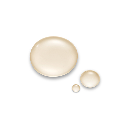 Drie druppels van het vloeibare serum uit het Inhibit Tensolift Neck Mask, met een lichte beige kleur en een glanzende, hydraterende textuur op een witte achtergrond.