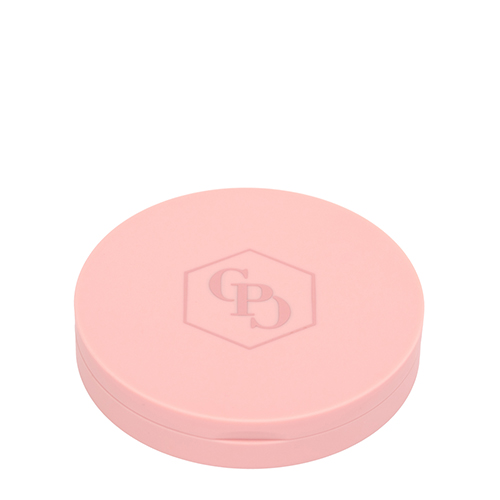 De buitenkant van een rond, matroze make-up doosje van Cent Pur Cent. In het midden van de deksel staat het logo van het merk subtiel in reliëf binnen een zeshoekig kader.