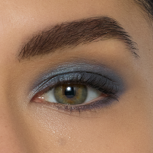 Close-up van een oog bij een model met een lichte huidskleur en groene ogen, opgemaakt met de glanzende Riviera oogschaduw.