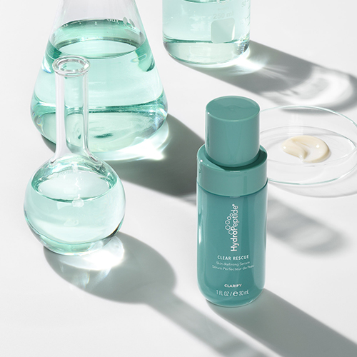 HydroPeptide Clear Rescue Serum flacon omringd door laboratoriumglaswerk met turquoise vloeistof