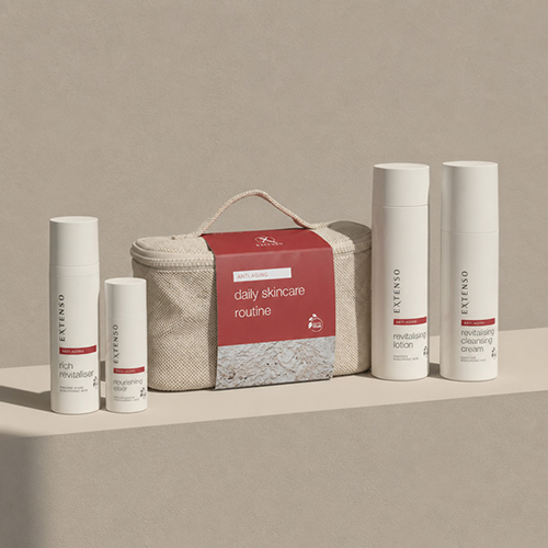 Extenso daily skincare routine anti aging set met vier witte flacons waaronder een rich revitaliser en revitalising lotion naast een rode verzorgingstas