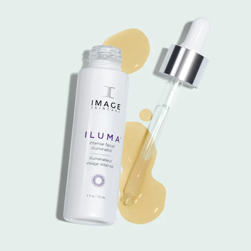 Een witte flacon van Image Skincare Iluma Intense Facial Illuminator liggend naast een glazen pipet met druppels geel serum op een lichtblauwe achtergrond.