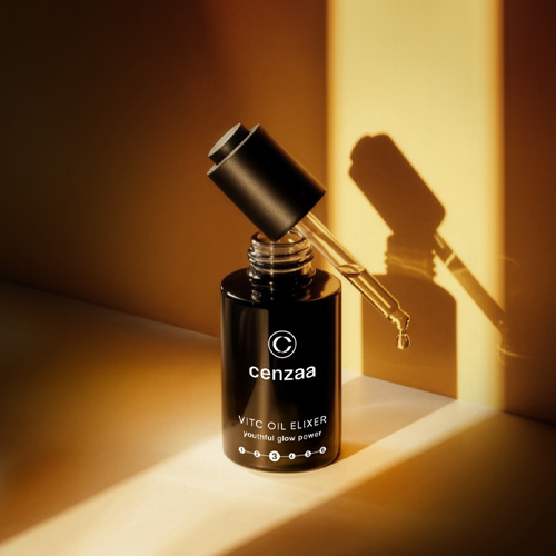 Open productverpakking van de Cenzaa VITC Oil Elixer tegen goudkleurige achtergrond