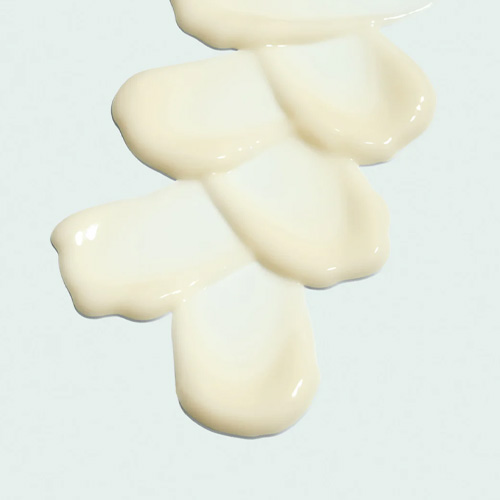 Een macro-opname van de lichte, gele verkoelende gel-textuur van de ORMEDIC oogverzorging die direct intrekt in de huid.