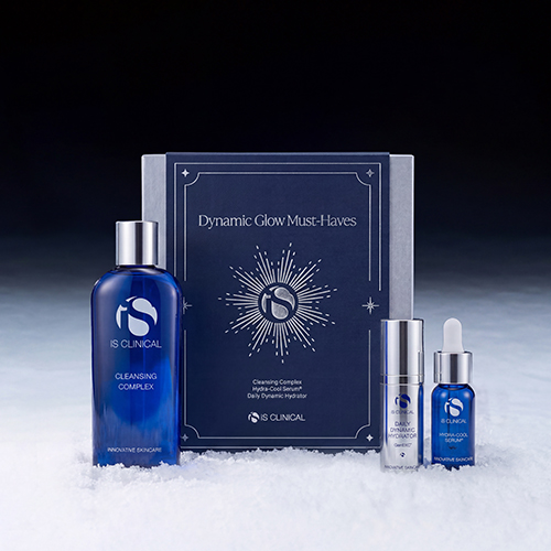 iS Clinical Dynamic Glow Must-Haves huidverzorgingsset op een winterse ondergrond met sneeuw en een donkere achtergrond