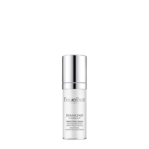 Een gecentreerde opname van een fles Natura Bissé Diamond Luminous Perfecting Serum met een zilveren dop en pomp, tegen een effen witte achtergrond.