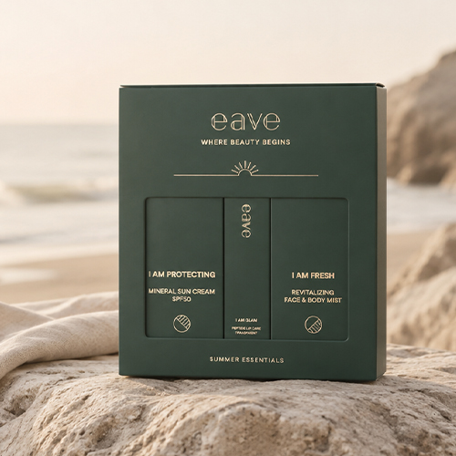 Een sfeervolle foto van de gesloten EAVE SUMMER ESSENTIALS BOX op een rots aan het strand tijdens zonsondergang.