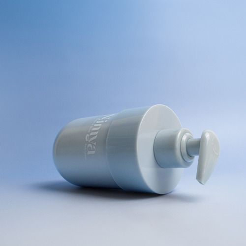 Een liggende fles Nimya bodylotion op een blauwe gradiënt achtergrond