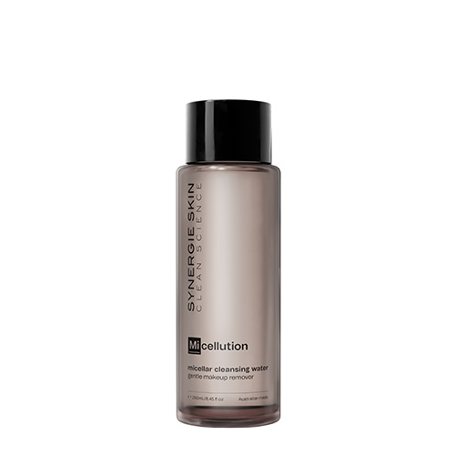 Een studio productfoto van een transparante bruine fles Synergie Skin Micellution micellair reinigingswater van 250ml met een zwarte dop tegen een volledig witte achtergrond.