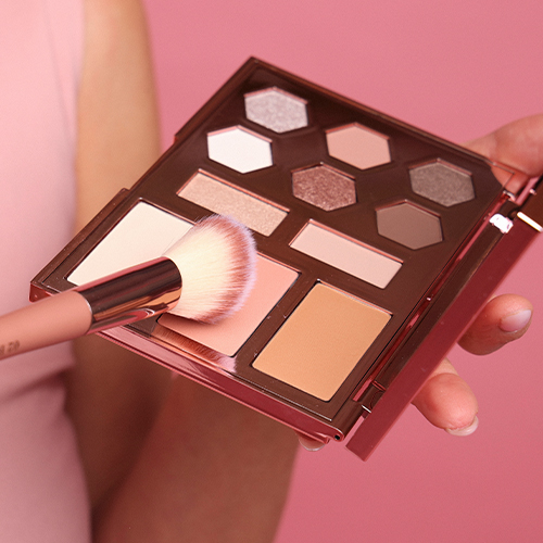 Een actiefoto waarbij een make-up kwast wordt gebruikt om poeder aan te brengen uit het Cent Pur Cent gezichtspalet.