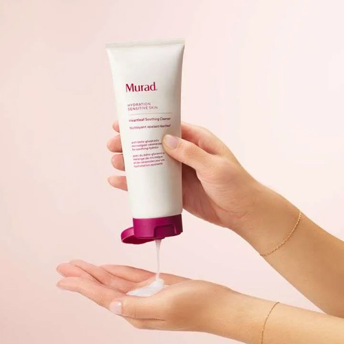 Iemand houdt een tube Murad Heartleaf Soothing Cleanser vast waar reinigingsgel uitkomt in de hand