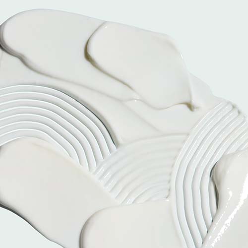 Een gedetailleerde weergave van de romige, witte en hydraterende textuur van de Iluma Intense Brightening Body Lotion.
