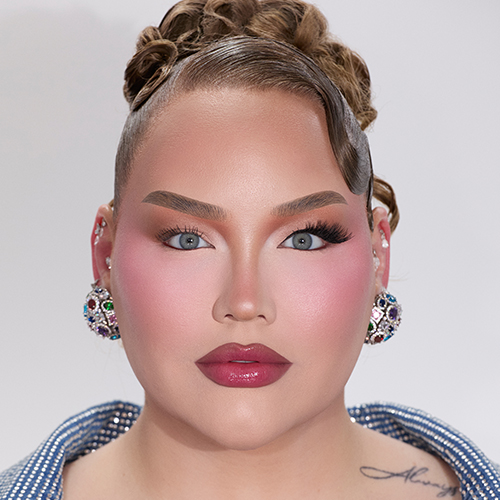 NikkieTutorials met haar make up look, waarbij haar linker oog (voor de kijker rechts) is voorzien van een volle nepwimper en haar rechter oog (voor de kijker links) alleen mascara heeft, ter vergelijking.