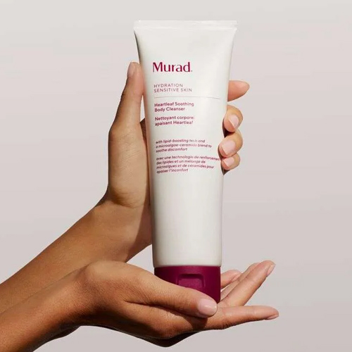 Hand die een grote tube Murad Heartleaf Soothing Body Cleanser vasthoudt