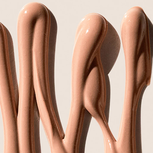 Macro-opname van de vloeibare, warm-beige getinte textuur van de Pure Mineral Tinted Moisturizer.