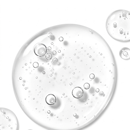 Close-up van de jane iredale BeautyPrep Face Cleanser textuur, bestaande uit heldere, transparante micellaire waterdruppels met kleine luchtbelletjes op een witte achtergrond.