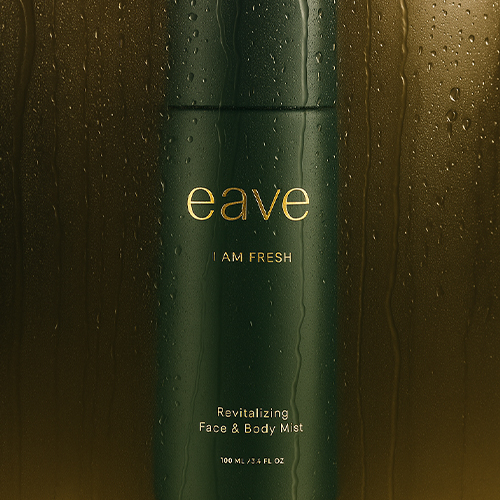 Close-up van de donkergroene Eave flacon bedekt met waterdruppels tegen een sfeervolle, goudbruine achtergrond met condens.