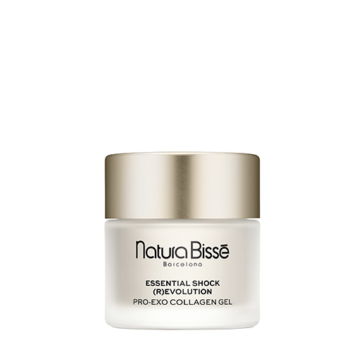 Een lachende vrouw houdt de pot Natura Bissé Essential Shock (R)evolution Pro-Exo Collagen Gel vast, gefotografeerd in een warme, elegante setting.