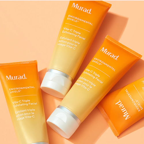 Meerdere tubes Murad Vita-C Triple Exfoliating Facial op een oranje ondergrond
